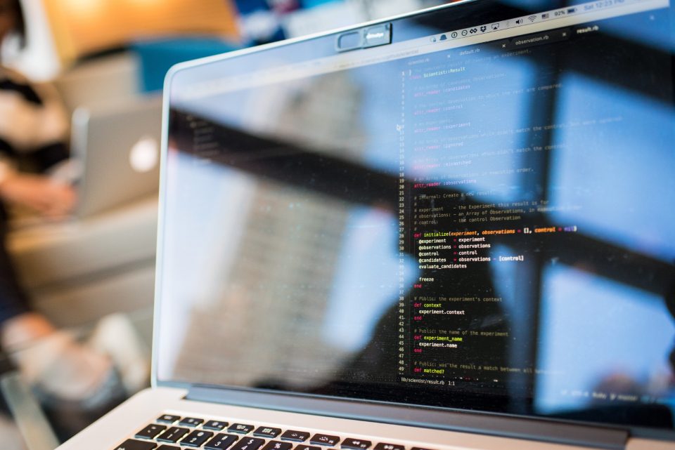 Software developer writing code on a laptop